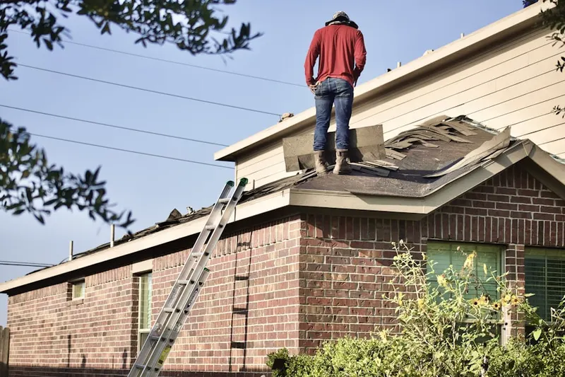 Professional roofer working on a residential roof in London Towne